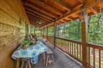 Main floor back porch offers a picnic table, rocking chairs and a gas grill 